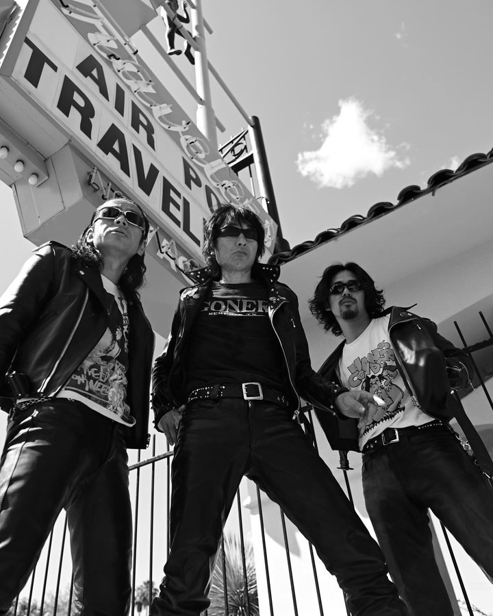 Guitar Wolf shot from below against a Las Vegas sky